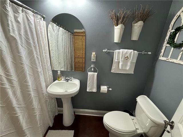 full bath with a shower with curtain, toilet, and baseboards