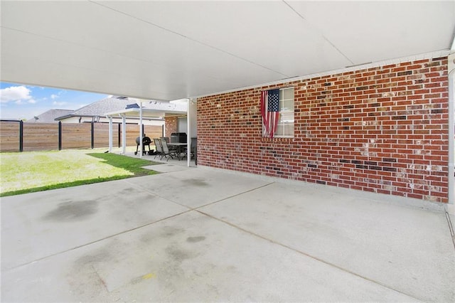 view of patio / terrace featuring an attached carport and fence