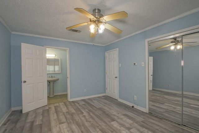 7984 Edgelake Ct, New Orleans, LA 70126 - unfurnished bedroom with visible vents, baseboards, ornamental molding, a textured ceiling, and wood finished floors