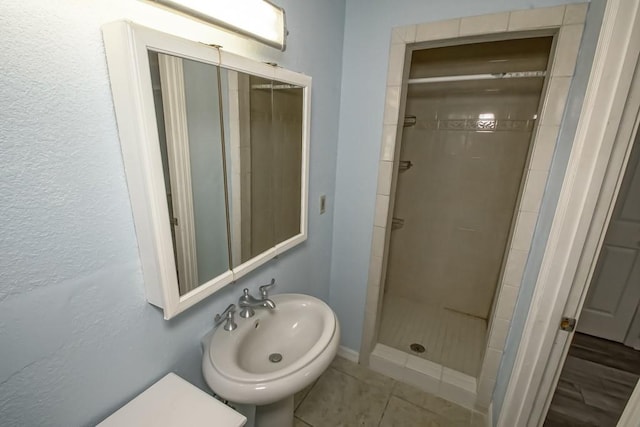 7984 Edgelake Ct, New Orleans, LA 70126 - bathroom featuring a stall shower, a sink, baseboards, and tile patterned floors