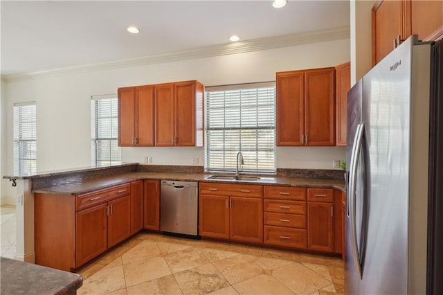 kitchen with recessed lighting, ornamental molding, stainless steel appliances, a sink, and a peninsula