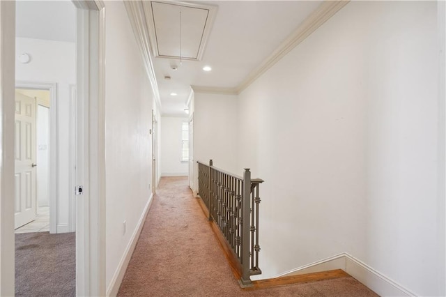 hallway featuring an upstairs landing, attic access, ornamental molding, carpet, and baseboards