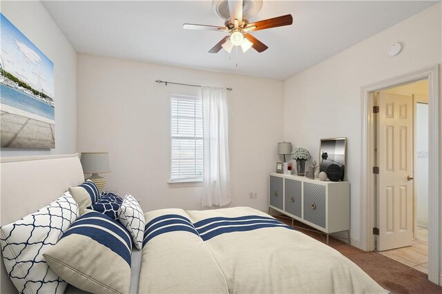 carpeted bedroom with baseboards and a ceiling fan