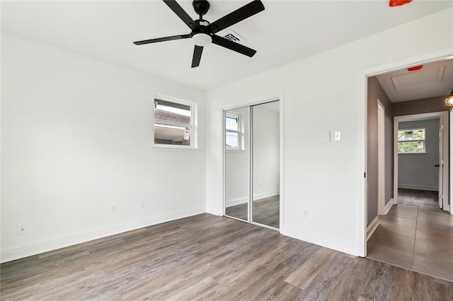 4904 Argonne St, Metairie, LA 70001 - unfurnished bedroom featuring attic access, multiple windows, wood finished floors, and a closet