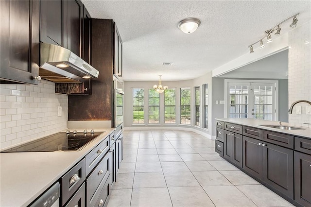 238 Blue Crane 1 Dr, Slidell, LA 70461 - kitchen featuring a notable chandelier, stainless steel oven, a sink, black electric cooktop, and under cabinet range hood