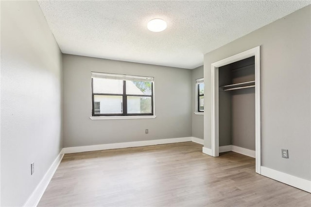 238 Blue Crane 1 Dr, Slidell, LA 70461 - unfurnished bedroom featuring a closet, a textured ceiling, baseboards, and wood finished floors