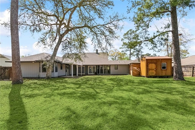 238 Blue Crane 1 Dr, Slidell, LA 70461 - back of property featuring a lawn, an outbuilding, fence, and a storage shed
