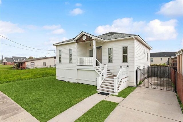 6309 Debore Dr, New Orleans, LA 70126 - view of front facade with driveway, a front yard, a gate, and roof with shingles