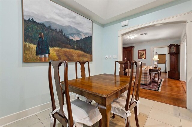 107 Stella St, Metairie, LA 70005 - dining area with light tile patterned flooring, arched walkways, and baseboards