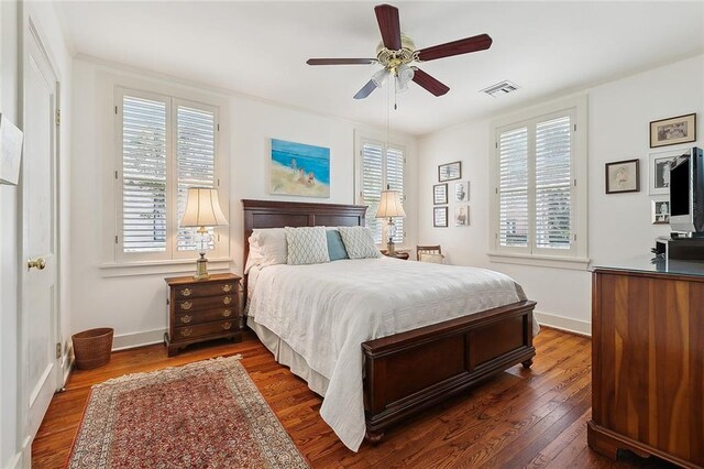 107 Stella St, Metairie, LA 70005 - bedroom featuring dark wood-style flooring, multiple windows, baseboards, and a ceiling fan