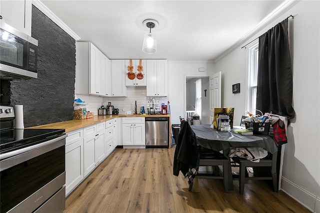 902931 Hickory St, New Orleans, LA 70118 - kitchen with appliances with stainless steel finishes, ornamental molding, wood counters, decorative backsplash, and light wood-type flooring