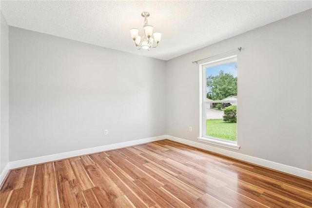 803 Lake Dcote Ct, Slidell, LA 70461 - empty room with a chandelier, light wood finished floors, and a textured ceiling