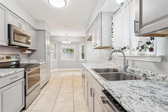 803 Lake Dcote Ct, Slidell, LA 70461 - kitchen featuring appliances with stainless steel finishes, a chandelier, a textured ceiling, light tile patterned floors, and decorative light fixtures