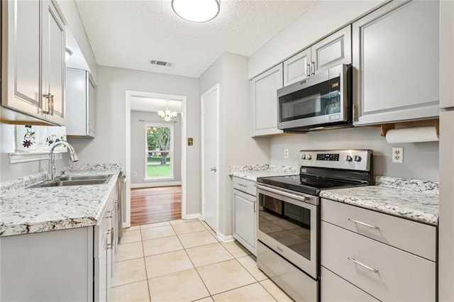 803 Lake Dcote Ct, Slidell, LA 70461 - kitchen featuring stainless steel appliances, a textured ceiling, gray cabinets, and a chandelier