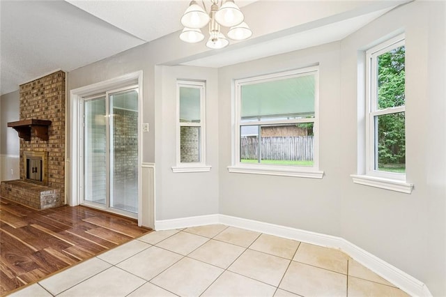 803 Lake Dcote Ct, Slidell, LA 70461 - unfurnished dining area featuring light tile patterned floors, a chandelier, and a fireplace