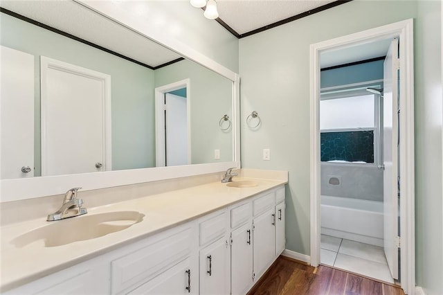 803 Lake Dcote Ct, Slidell, LA 70461 - bathroom featuring wood finished floors, double vanity, crown molding, a bath, and baseboards