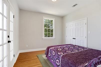 bedroom featuring visible vents, baseboards, and wood finished floors