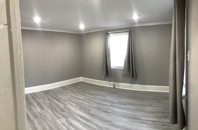 empty room with recessed lighting, crown molding, baseboards, and wood finished floors
