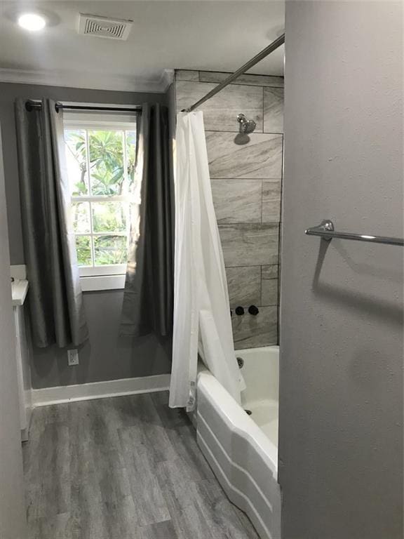 full bathroom featuring visible vents, baseboards, shower / bathtub combination with curtain, and wood finished floors