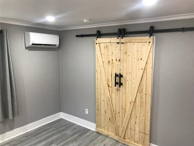 basement with dark wood finished floors, baseboards, crown molding, and a wall mounted air conditioner