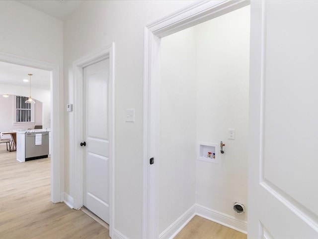 laundry area featuring baseboards, washer hookup, light wood-style floors, and laundry area