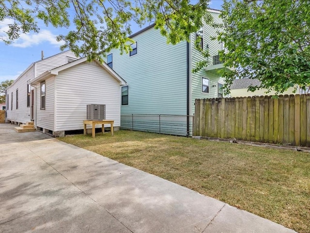 back of property featuring a yard, fence, and entry steps