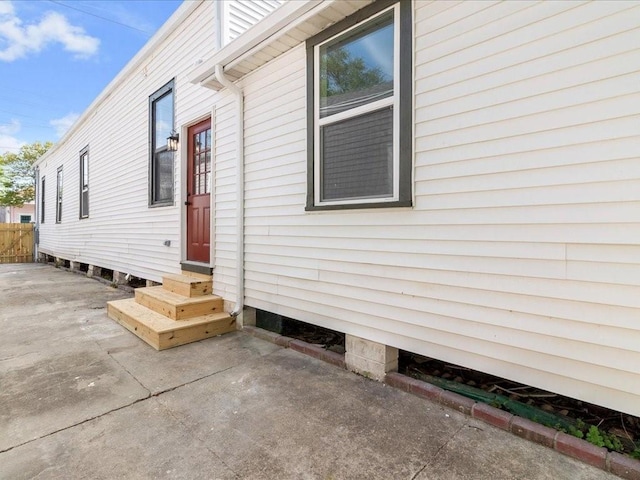 view of side of property with fence and entry steps