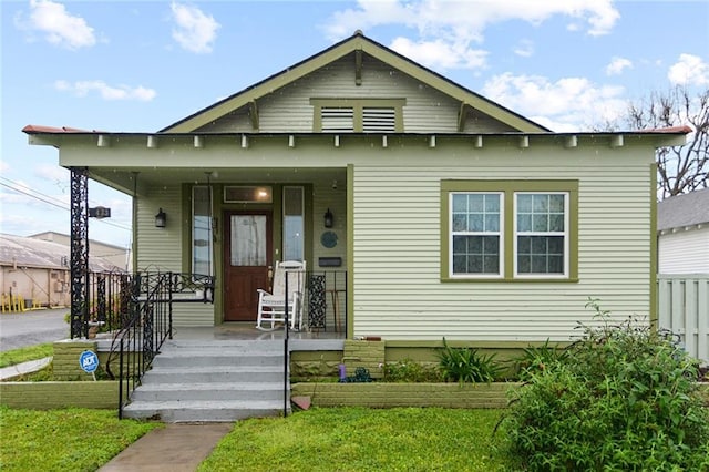 bungalow-style home with a front lawn and covered porch