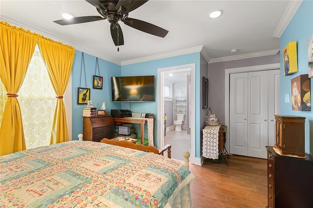 bedroom with baseboards, crown molding, wood finished floors, and a closet