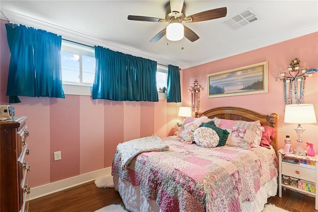 bedroom featuring a ceiling fan, wood finished floors, baseboards, ornamental molding, and visible vents