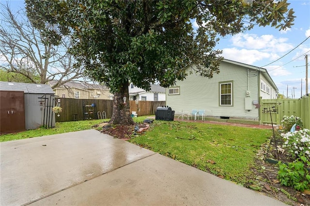 rear view of house with a fenced backyard, a patio area, a storage shed, and a lawn
