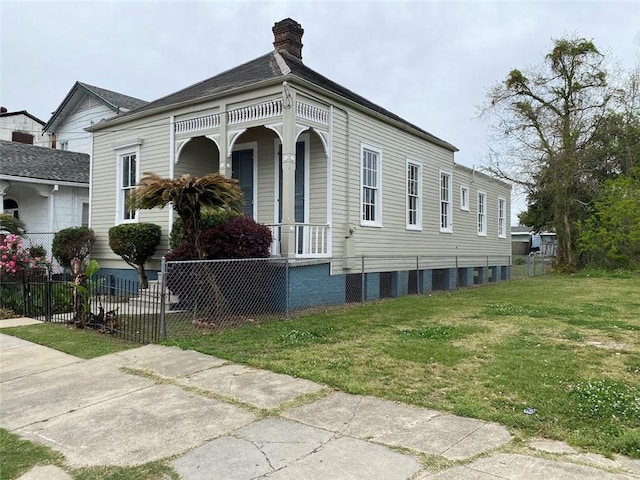 3321 Baronne St, New Orleans, LA 70113 - view of front of house featuring a porch, a front yard, a fenced front yard, and a chimney