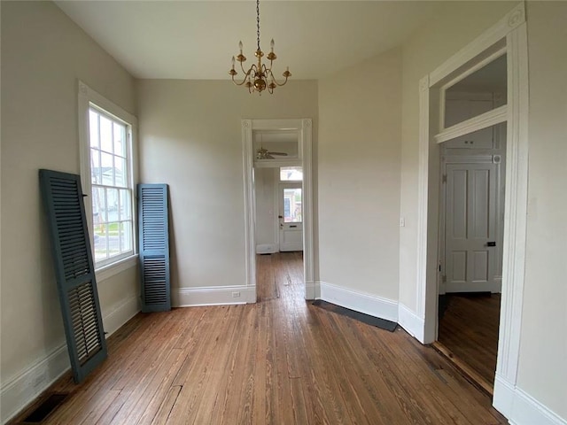 3321 Baronne St, New Orleans, LA 70113 - unfurnished dining area featuring visible vents, a heating unit, baseboards, dark wood finished floors, and an inviting chandelier