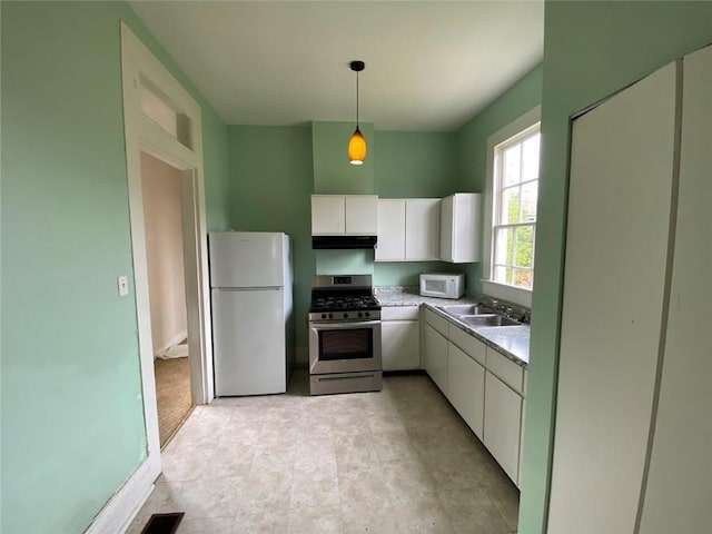 3321 Baronne St, New Orleans, LA 70113 - kitchen featuring white cabinets, light countertops, white appliances, under cabinet range hood, and decorative light fixtures