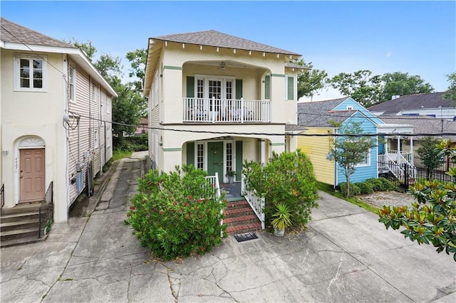 441921 Fontainebleau Dr, New Orleans, LA 70125 - view of front of home with a balcony, a ceiling fan, stucco siding, covered porch, and a shingled roof