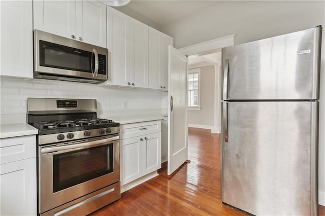 441921 Fontainebleau Dr, New Orleans, LA 70125 - kitchen with white cabinetry, light countertops, stainless steel appliances, decorative backsplash, and wood finished floors