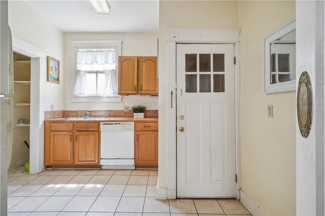 441921 Fontainebleau Dr, New Orleans, LA 70125 - kitchen with light countertops, a sink, light tile patterned flooring, white dishwasher, and brown cabinets