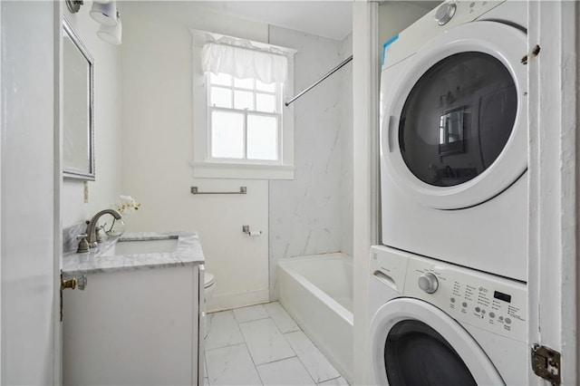 441921 Fontainebleau Dr, New Orleans, LA 70125 - clothes washing area featuring baseboards, marble finish floor, a sink, stacked washer / dryer, and laundry area