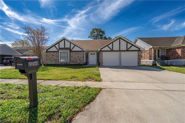 2260 Killington Dr, Harvey, LA 70058 - tudor-style house featuring driveway, a front yard, an attached garage, and brick siding
