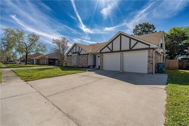 2260 Killington Dr, Harvey, LA 70058 - english style home featuring a garage, concrete driveway, fence, and a front yard