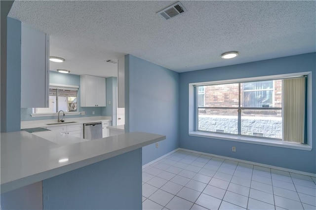 2260 Killington Dr, Harvey, LA 70058 - kitchen with light countertops, a sink, stainless steel dishwasher, visible vents, and white cabinets