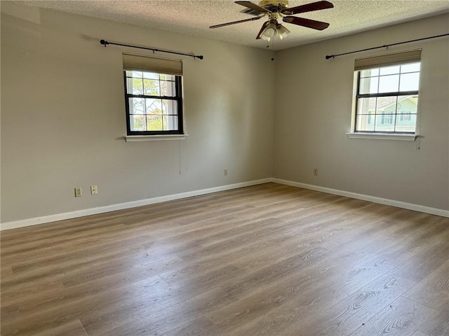 230 Evella Dr, Slidell, LA 70458 - empty room featuring a textured ceiling, healthy amount of natural light, wood finished floors, ceiling fan, and baseboards