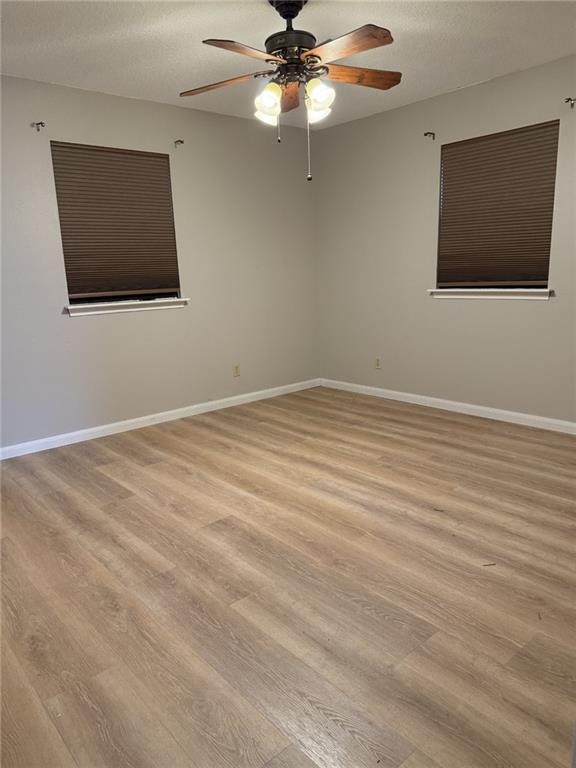 230 Evella Dr, Slidell, LA 70458 - empty room featuring light wood finished floors, a ceiling fan, baseboards, and a textured ceiling