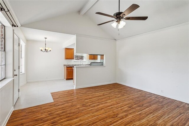 545 Brookmeade Dr, Gretna, LA 70056 - unfurnished living room with beamed ceiling, high vaulted ceiling, light wood finished floors, ceiling fan with notable chandelier, and a sink