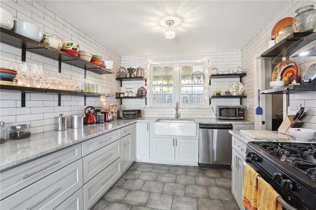 3701 Marigny St, New Orleans, LA 70122 - kitchen featuring a sink, decorative backsplash, appliances with stainless steel finishes, and open shelves