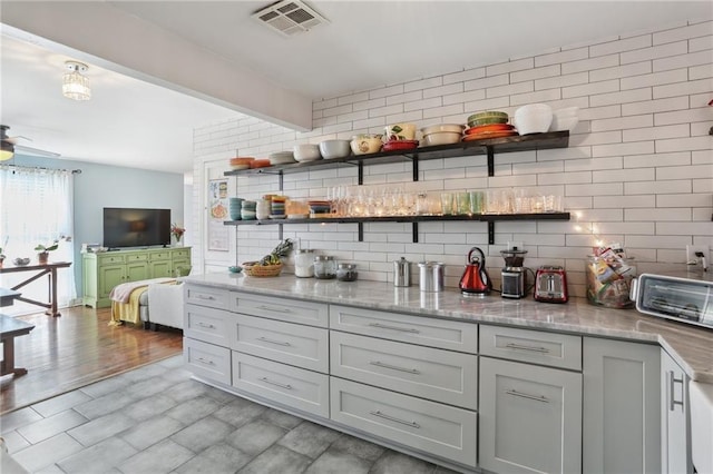 3701 Marigny St, New Orleans, LA 70122 - kitchen with visible vents, beamed ceiling, tasteful backsplash, open shelves, and light stone counters