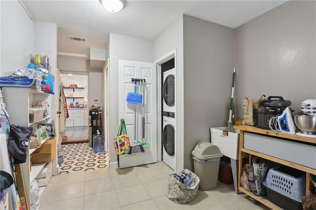 3701 Marigny St, New Orleans, LA 70122 - clothes washing area featuring light tile patterned floors, stacked washer and dryer, and visible vents