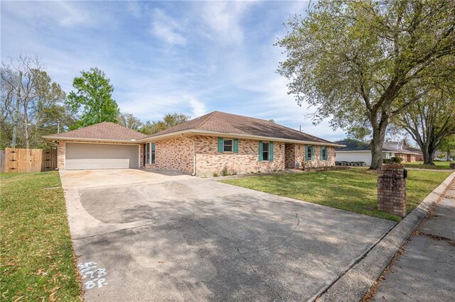 128 Belle Grove Dr, La Place, LA 70068 - ranch-style home featuring fence, an attached garage, concrete driveway, a front yard, and brick siding