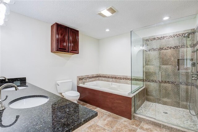 128 Belle Grove Dr, La Place, LA 70068 - bathroom featuring a bath, a textured ceiling, toilet, a sink, and a stall shower