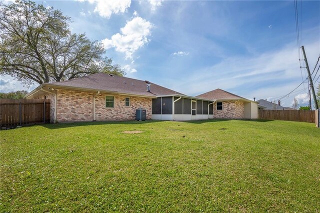 128 Belle Grove Dr, La Place, LA 70068 - rear view of property featuring cooling unit, a sunroom, a fenced backyard, and a yard